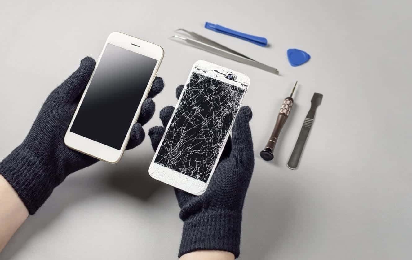 Hands repairing a broken cell phone.