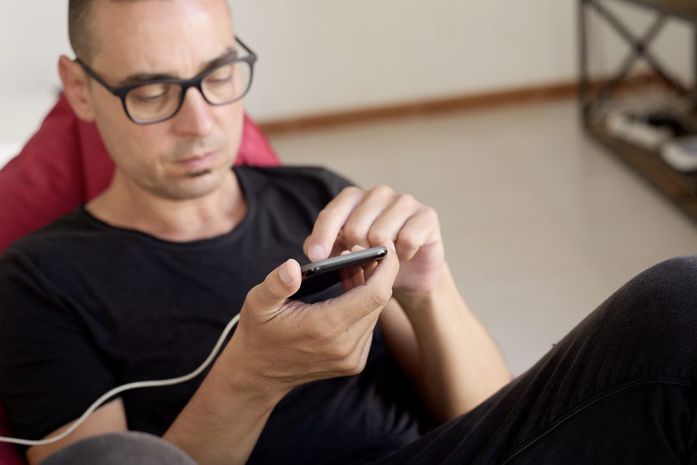 man using phone while charging