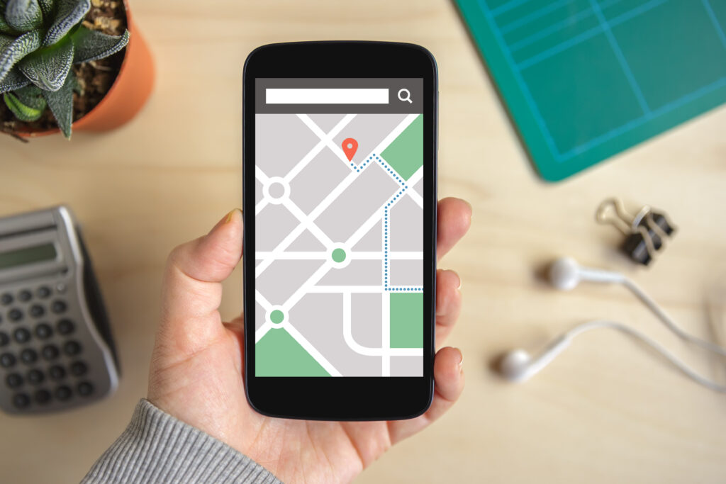 Hand holding smart phone with map gps navigation application on